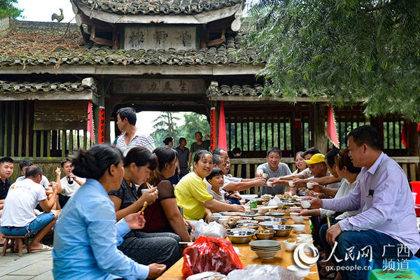 7月26日,在广西龙胜各族自治县乐江镇地灵村,侗族群众与八方来客共享“百家宴”。